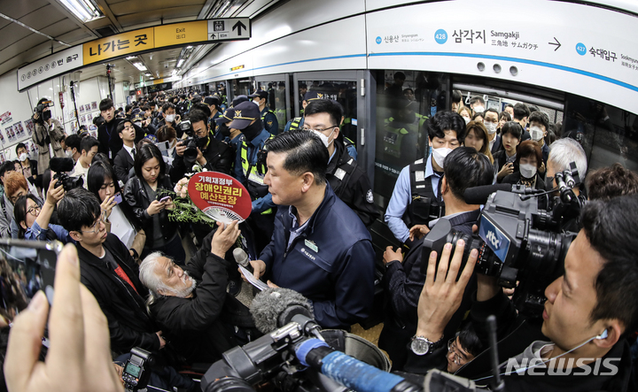 [서울=뉴시스] 김근수 기자 = 박경석 전국장애인차별철폐연대 상임대표와 회원들이 20일 서울 용산구 지하철 4호선 삼각지역에서 장애인의 날을 맞아 출근길 지하철 탑승시위를 하고 있다. 2023.04.20. ks@newsis.com