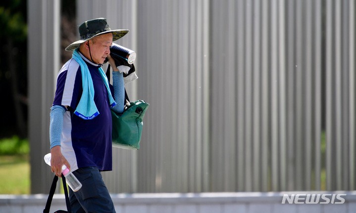 [광주=뉴시스] 이영주 기자 = 낮 최고기온 28도를 기록하며 초여름 날씨를 보인 20일 오후 광주 서구 5·18기념공원에서 공원 관리에 투입된 한 인부가 물병으로 더위를 식히고 있다. 2023.04.20. leeyj2578@newsis.com