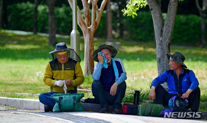 [광주=뉴시스] 이영주 기자 = 낮 최고기온 28도를 기록하며 초여름 날씨를 보인 20일 오후 광주 서구 5·18기념공원에서 공원 관리에 투입된 인부들이 그늘에서 더위를 식히고 있다. 2023.04.20. leeyj2578@newsis.com