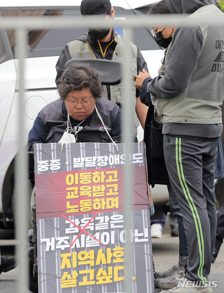 [서울=뉴시스] 김금보 기자 = 이형숙 서울장애인차별철폐연대 공동대표가 지난해 4월20일 서울 영등포구 63컨벤션센터 앞에서 열린 '장애인의날을 거부하는 자들의 장애인차별철폐의날 기념식'에서 차도 점거를 하고 있다. 2023.04.20. kgb@newsis.com