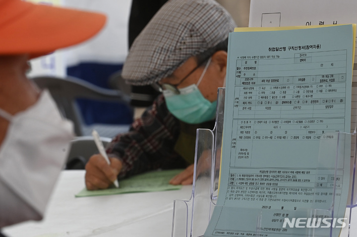 [수원=뉴시스] 김종택 기자 = 20일 오후 경기도 수원시 화성행궁광장에서 열린 '노인일자리 채용한마당'을 찾은 어르신이 구직신청서를 작성하고 있다. 2023.04.20. jtk@newsis.com