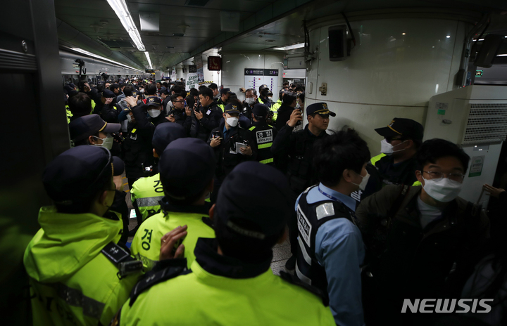 [서울=뉴시스] 고승민 기자 = 전국장애인차별철폐연대 회원들이 21일 서울 광화문역 열차 승강장에서 선전전 및 열차 탑승을 시도하는 가운데 많은 경찰과 시민이 함께 몰려 혼잡을 빚고 있다. 2023.04.21. kkssmm99@newsis.com