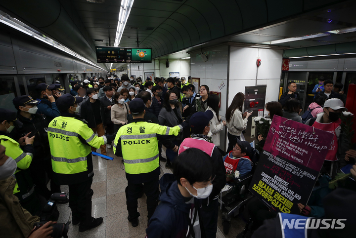 [서울=뉴시스] 고승민 기자 = 전국장애인차별철폐연대 회원들이 21일 서울 광화문역 열차 승강장에서 선전전 및 열차 탑승을 시도하는 가운데 많은 경찰과 시민이 함께 몰려 혼잡을 빚고 있다. 2023.04.21. kkssmm99@newsis.com