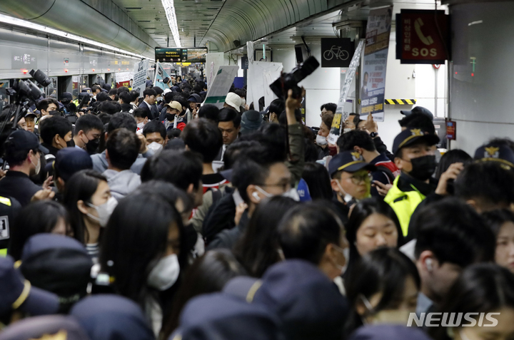 [서울=뉴시스] 고승민 기자 = 전국장애인차별철폐연대 회원들이 21일 서울 광화문역 열차 승강장에서 선전전 및 열차 탑승을 시도하는 가운데 많은 경찰과 시민이 함께 몰려 혼잡을 빚고 있다. 2023.04.21. kkssmm99@newsis.com