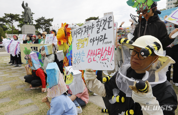 [서울=뉴시스] 고승민 기자 = 환경단체 소비자기후행동과 시민들이 22일 서울 남산공원 백범광장에서 지구의 날을 맞아 남산 둘레길 걷기 캠페인을 하기 전 포즈를 취하고 있다. 2023.04.22. kkssmm99@newsis.com