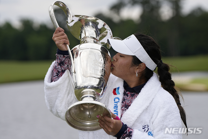 [우드랜드=AP/뉴시스] 릴리아 부(미국)가 23일(현지시간) 미 텍사스주 우드랜드의 더 클럽 앳 칼턴 우즈에서 열린 미국여자프로골프(LPGA)투어 셰브런 챔피언십 정상에 올라 연못에 뛰어든 후 트로피를 들고 입 맞추고 있다. 부는 최종 합계 10언더파 278타로 에인절 인(미국)과 동타를 이뤄 연장 끝에 우승하며 LPGA 통산 2승을 거뒀다. 2023.04.24.