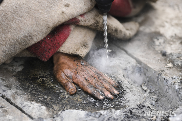 [베를린=AP/뉴시스]독일 수도 베를린에서 24일 정부의 기후 정책에 반대하기 위해 강력 접착제로 자신의 몸을 도로에 붙여 교통 흐름 차단에 나선 기후단체 회원의 손이 붙어 있는 도로를 독일 경찰이 굴착기를 이용해 뜯어내려 하고 있다. 독일 기후 운동가들이 이날 아침 수도 베를린에서 강력 접착제로 자신들의 몸을 도로에 붙임으로써 수도 전체의 교통을 마비시키려 했다. 2023.04.24.