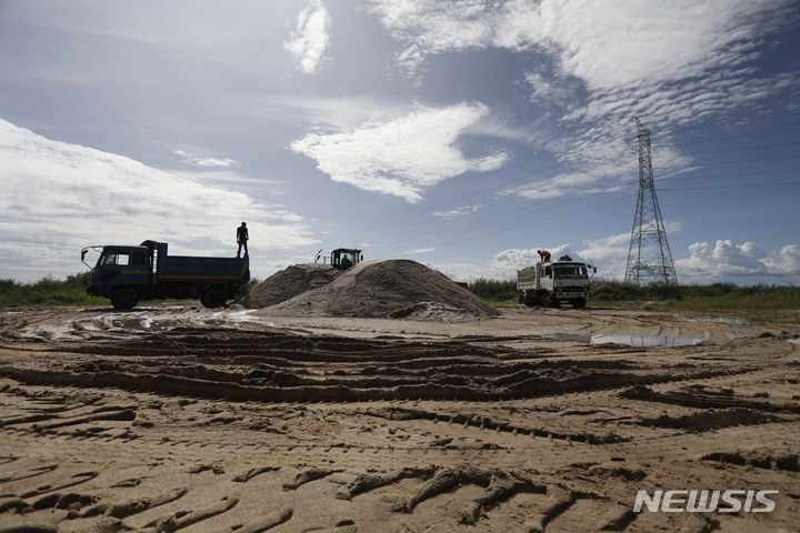  [루카야(우간다)=AP/뉴시스]우간다 루카야 지역의 르웨라 습지안에서 지난 4월5일 세로마 모래채취회사가 트럭으로 모래를 퍼담아 반출하고 있다. 우간다는 기후재앙의 원인이 습지 감소라 여기고 전국의 습지 명단을 발표, 보호에 나섰다. 2023.11.20. 
