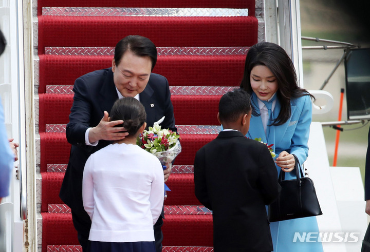[워싱턴=뉴시스] 전신 기자 = 미국을 국빈 방문한 윤석열 대통령과 부인 김건희 여사가 24일(현지시간) 워싱턴DC 인근 앤드루스 공군기지에 도착해 꽃다발을 선물한 화동과 인사하고 있다. 2023.04.25. photo1006@newsis.com