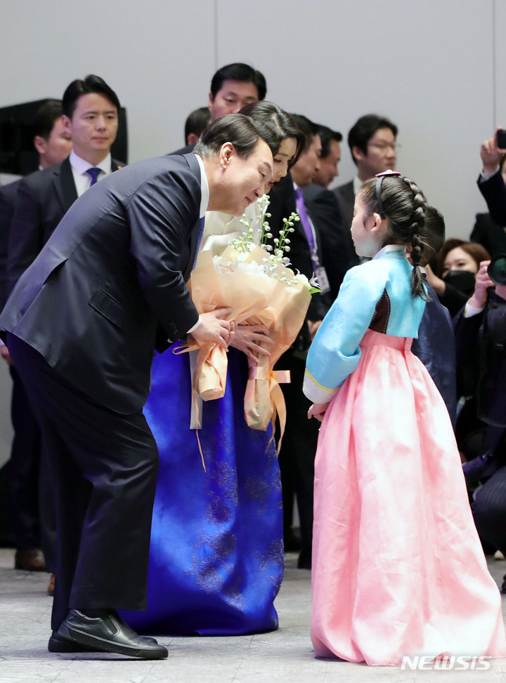 [워싱턴=뉴시스] 홍효식 기자 = 윤석열 대통령과 부인 김건희 여사가 24일(현지시간) 워싱턴 한 호텔에서 열린 워싱턴 동포 초청 만찬 간담회에 앞서 화동에게 꽃다발을 전달받고 있다. 2023.04.25. yesphoto@newsis.com