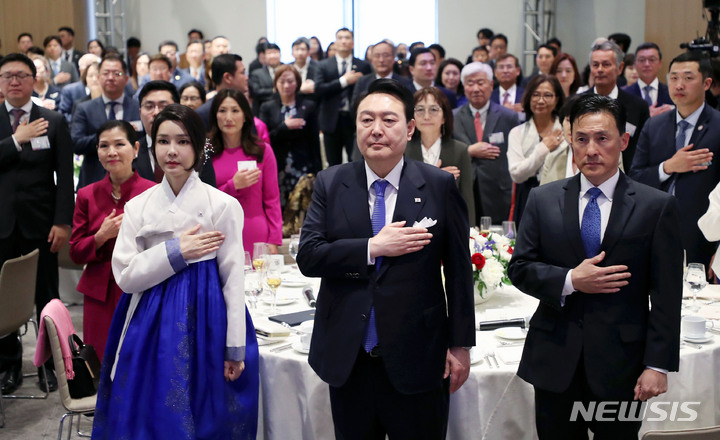 [워싱턴=뉴시스] 홍효식 기자 = 윤석열 대통령과 부인 김건희 여사가 24일(현지시간) 워싱턴 한 호텔에서 열린 워싱턴 동포 초청 만찬 간담회에서 국기에 대한 경례를 하고 있다. 2023.04.25. yesphoto@newsis.com