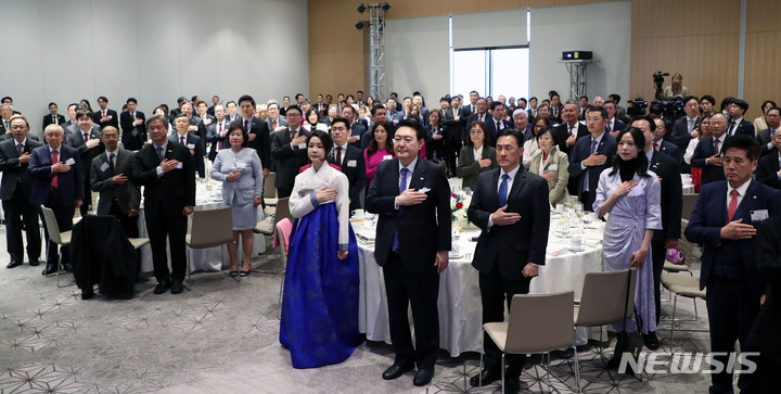 [워싱턴=뉴시스] 홍효식 기자 = 윤석열 대통령과 부인 김건희 여사가 24일(현지시간) 워싱턴 한 호텔에서 열린 워싱턴 동포 초청 만찬 간담회에서 국기에 대한 경례를 하고 있다. 2023.04.25. yesphoto@newsis.com