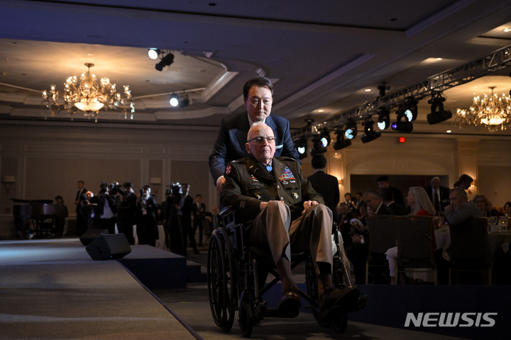 [워싱턴=뉴시스] 홍효식 기자 = 한국전쟁 참전용사 랠프 퍼켓 미 육군 예비역 대령이 97세를 일기로 별세했다고 8일(현지시각) 뉴욕타임스(NYT)가 보도했다. 사진은 윤석열 대통령이 지난해 4월25일 워싱턴DC 한 호텔에서 열린 한미동맹 70주년 기념 오찬에서 참전용사들에게 태극 무공훈장을 수여하기 위해 퍼켓 예비역 육군 대령의 휠체어를 밀어주는 모습. 2024.04.09. (공동취재) yesphoto@newsis.com