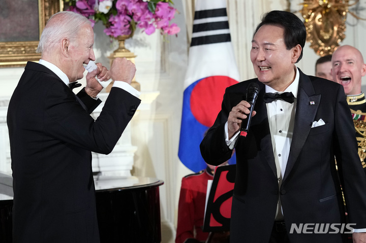 [워싱턴=AP/뉴시스] 윤석열 대통령이 26일(현지시간) 백악관에서 열린 국빈만찬을 마친 후 조 바이든 대통령과 함께 무대에 올라 미국의 싱어송라이터 돈 맥클린의 '아메리칸 파이'를 부르고 있다. 2023.04.27.
