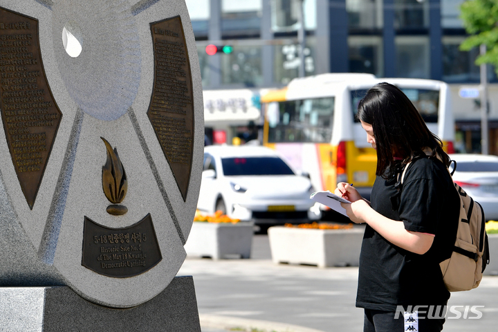 [광주=뉴시스] 이영주 기자 = 5·18민주화운동 43주기를 3주 앞둔 27일 오전 광주 동구 5·18민주광장에서 현장학습을 나온 지역 한 초등학생이 5·18 사적지 안내 표지석의 내용을 수첩에 적고 있다. 2023.04.27. leeyj2578@newsis.com