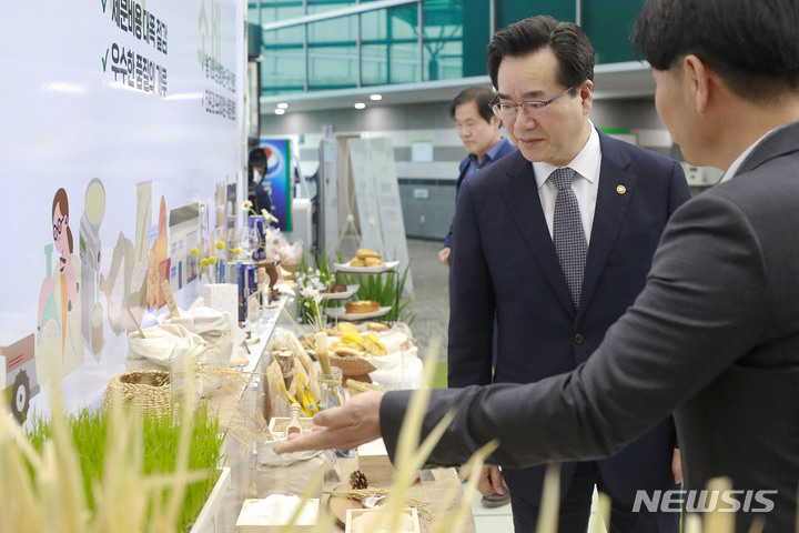 [서울=뉴시스] 최동준 기자 = 정황근 농림축산식품부 장관이 27일 서울 서초구 aT센터에서 열린 가루쌀 산업 활성화 미래 비전 선포식에 참석해 가루쌀로 만든 식품 설명을 듣고 있다. 2023.04.27. photocdj@newsis.com