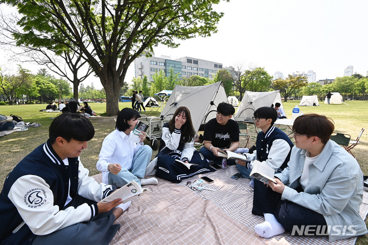 [수원=뉴시스] 김종택 기자 = 봄기운이 완연한 27일 경기도 수원시 성균관대학교 자연과학캠퍼스 잔디밭에서 '북 피크닉' 행사에 참여한 학생들이 이야기를 나누며 책을 읽고 있다. 2023.04.27. jtk@newsis.com