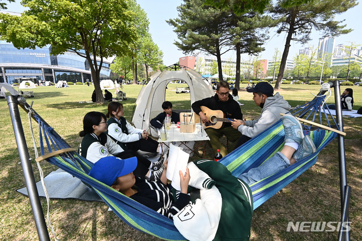 [수원=뉴시스] 김종택 기자 = 봄기운이 완연한 27일 경기도 수원시 성균관대학교 자연과학캠퍼스 잔디밭에서 '북 피크닉' 행사에 참여한 학생들이 이야기를 나누며 책을 읽고 있다. 2023.04.27. jtk@newsis.com