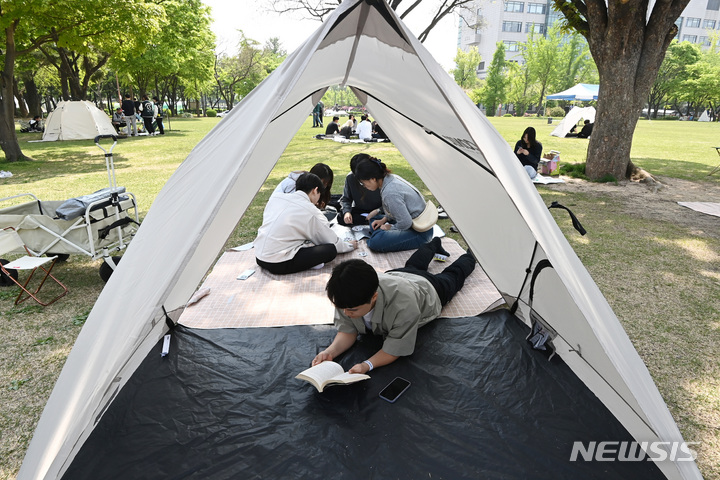 [수원=뉴시스] 김종택 기자 = 봄기운이 완연한 27일 경기도 수원시 성균관대학교 자연과학캠퍼스 잔디밭에서 '북 피크닉' 행사에 참여한 학생들이 이야기를 나누며 책을 읽고 있다. 2023.04.27. jtk@newsis.com