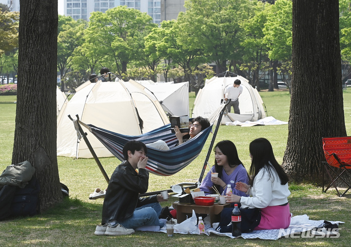 [수원=뉴시스] 김종택 기자 = 봄기운이 완연한 27일 경기도 수원시 성균관대학교 자연과학캠퍼스 잔디밭에서 '북 피크닉' 행사에 참여한 학생들이 이야기를 나누며 책을 읽고 있다. 2023.04.27. jtk@newsis.com