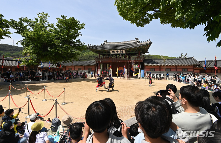 [수원=뉴시스] 김종택 기자 = 봄기운이 완연한 28일 경기도 수원시 팔달구 화성행궁을 찾은 시민들이 수원시립공연단원들의 무예24기 공연을 관람하고 있다. 2023.04.28. jtk@newsis.com