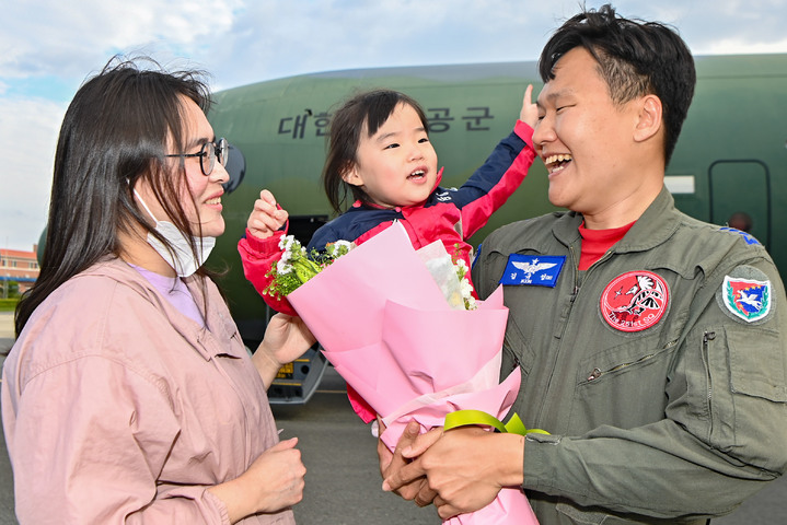 [서울=뉴시스] 최동준 기자 = 28일 오후 공군 김해기지에서 '프라미스(PROMISE)' 작전을 성공적으로 마치고 복귀한 김규성 대위가 가족들과 재회하고 있다. C-130J 임무요원들은 수단의 우리 국민들을 포트수단에서 사우디아라비아 제다공항으로 안전하게 후송하며 성공적으로 임무를 완수했다. (사진=공군 제공) 2023.04.28. photo@newsis.com *재판매 및 DB 금지