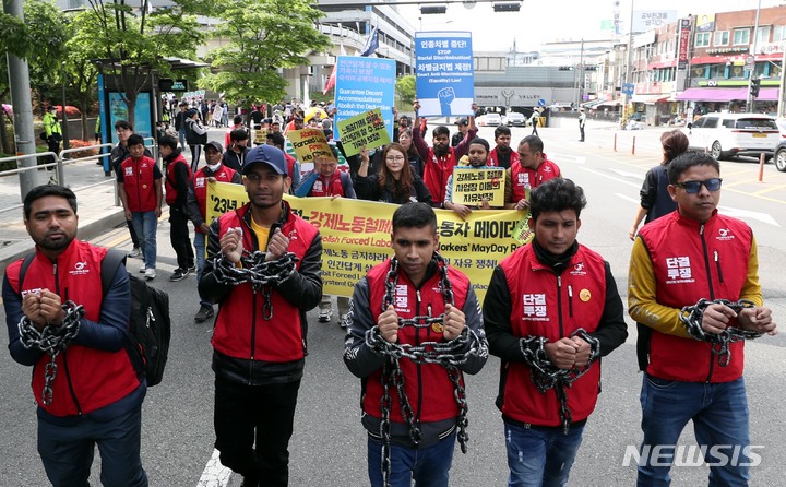 [서울=뉴시스] 조성봉 기자 = 30일 오후 서울 용산구 용산역 광장에서 ‘2023 세계노동절, 강제노동철폐! 이주노동자 메이데이 집회’를 마친 이주노동자들이 손목에 쇠사슬을 감는 퍼포먼스를 하며 대통령 집무실 방향으로 행진하고 있다. 참가자들은 성명서를 통해 이주 노동자의 체류와 임금, 노동조건 차별 철폐 및 권리 보장을 정부에 촉구했다. 2023.04.30. suncho21@newsis.com