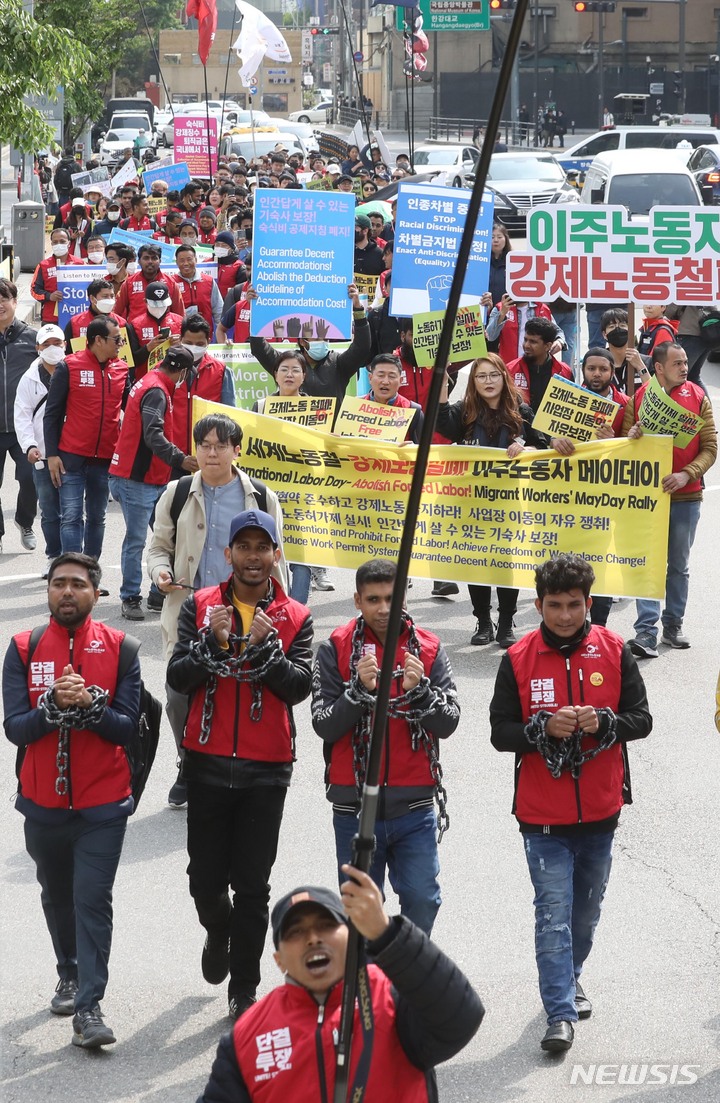[서울=뉴시스] 조성봉 기자 = 30일 오후 서울 용산구 용산역 광장에서 ‘2023 세계노동절, 강제노동철폐! 이주노동자 메이데이 집회’를 마친 이주노동자들이 손목에 쇠사슬을 감는 퍼포먼스를 하며 대통령 집무실 방향으로 행진하고 있다. 참가자들은 성명서를 통해 이주 노동자의 체류와 임금, 노동조건 차별 철폐 및 권리 보장을 정부에 촉구했다. 2023.04.30. suncho21@newsis.com