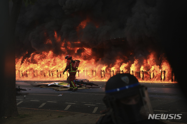 [파리=AP/뉴시스] 1일(현지시간) 프랑스 파리에서 노동절을 맞아 열린 연금개혁 반대 시위에서 화재가 발생해 소방대원이 진화 작업을 하고 있다. 2023.05.02.