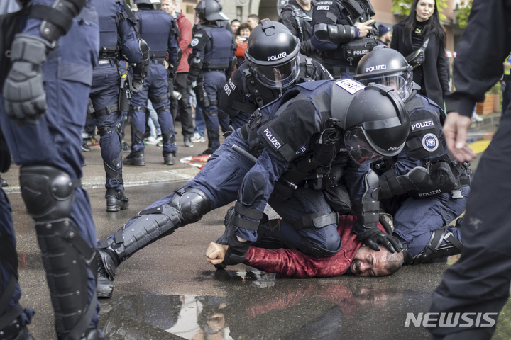 [취리히=AP/뉴시스] 1일(현지시간) 스위스 취리히에서 열린 노동절 집회에서 경찰이 시위대를 체포하고 있다. 2023.05.02.