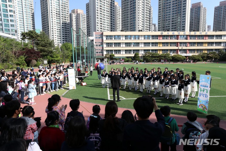 [서울=뉴시스] 조성봉 기자 = 3일 오전 서울 서초구 잠원초등학교에서 열린 ‘'등교맞이 음악회'에서 학생들과 학부모들이 합창단 어린이들의 공연을 관람하고 있다. 서초구는 가정의 달을 맞이해 이달 3, 4일 양일간 잠원초등학교에서 합창부와 오케스트라가 함께하는 ‘등교 맞이 음악회’를 연다. 2023.05.03. suncho21@newsis.com