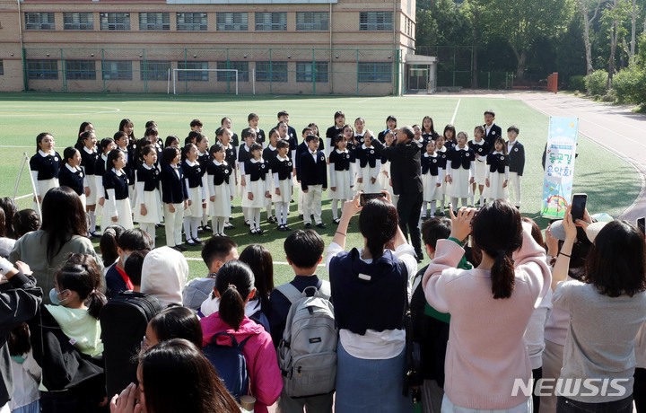 [서울=뉴시스] 조성봉 기자 = 3일 오전 서울 서초구 잠원초등학교에서 열린 ‘'등교맞이 음악회'에서 학생들과 학부모들이 합창단 어린이들의 공연을 관람하고 있다. 서초구는 가정의 달을 맞이해 이달 3, 4일 양일간 잠원초등학교에서 합창부와 오케스트라가 함께하는 ‘등교 맞이 음악회’를 연다. 2023.05.03. suncho21@newsis.com