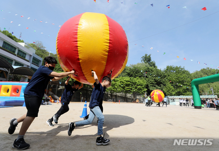 [서울=뉴시스] 김진아 기자 = 지난 3일 서울 동작구 본동초등학교에서 열린 '본동 놀이 한마당' 운동회에서 학생들이 슈퍼볼 나르기를 하고  있다. 2023.05.03. bluesoda@newsis.com