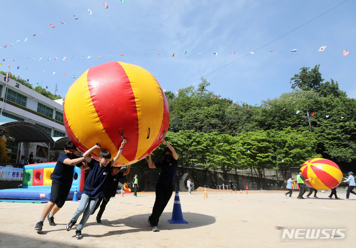 [서울=뉴시스] 김진아 기자 = 지난 3일 서울 동작구 본동초등학교에서 열린 '본동 놀이 한마당' 운동회에서 학생들이 슈퍼볼 나르기를 하고 있다. 2023.05.03. bluesoda@newsis.com