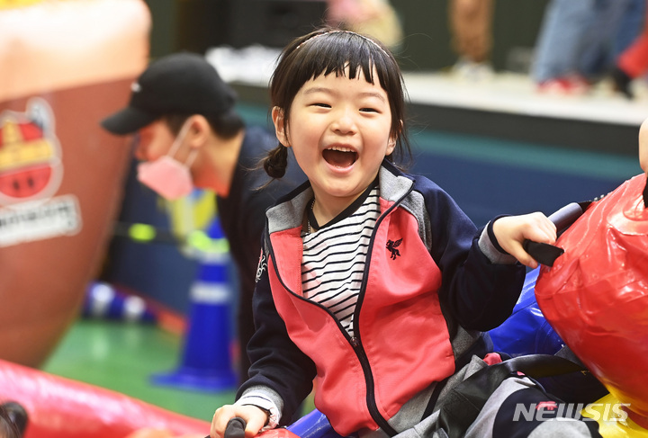 [수원=뉴시스] 김종택 기자 = 3일 경기도 수원시 장안구 수원실내체육관에서 수원시어린이집연합회 주최로 열린 '모여라 친구들,밖에서 놀자'에서 어린이들이 놀이기구를 타며 즐거워하고 있다. 2023.05.03. jtk@newsis.com