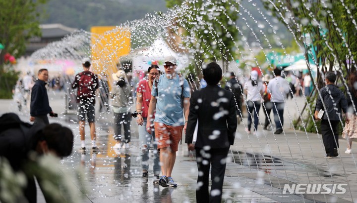 [서울=뉴시스] 김선웅 기자 = 서울 낮 최고기온이 26도를 기록한 3일 오후 서울 종로구 광화문광장 분수에서 내외국인 관광객들이 시원한 물줄기를 만끽하고 있다. 2023.05.03. mangusta@newsis.com
