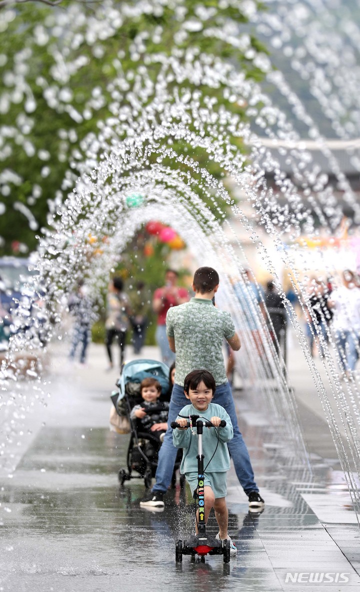 [서울=뉴시스] 김선웅 기자 = 서울 낮 최고기온이 26도를 기록한 3일 오후 서울 종로구 광화문광장 분수에서 내외국인 관광객들이 시원한 물줄기를 만끽하고 있다. 2023.05.03. mangusta@newsis.com