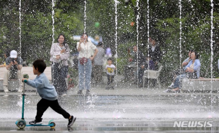 [서울=뉴시스] 김선웅 기자 = 서울 낮 최고기온이 26도를 기록한 3일 오후 서울 종로구 광화문광장 분수에서 내외국인 관광객들이 시원한 물줄기를 만끽하고 있다. 2023.05.03. mangusta@newsis.com