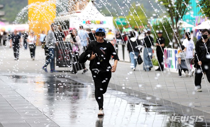 [서울=뉴시스] 김선웅 기자 = 서울 낮 최고기온이 26도를 기록한 3일 오후 서울 종로구 광화문광장 분수에서 내외국인 관광객들이 시원한 물줄기를 만끽하고 있다. 2023.05.03. mangusta@newsis.com