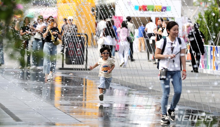 [서울=뉴시스] 김선웅 기자 = 서울 낮 최고기온이 26도를 기록한 3일 오후 서울 종로구 광화문광장 분수에서 내외국인 관광객들이 시원한 물줄기를 만끽하고 있다. 2023.05.03. mangusta@newsis.com