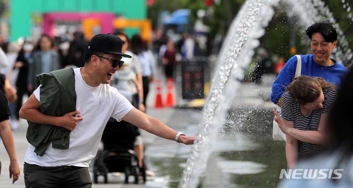 [서울=뉴시스] 김선웅 기자 = 서울 낮 최고기온이 26도를 기록한 3일 오후 서울 종로구 광화문광장 분수에서 내외국인 관광객들이 시원한 물줄기를 만끽하고 있다. 2023.05.03. mangusta@newsis.com