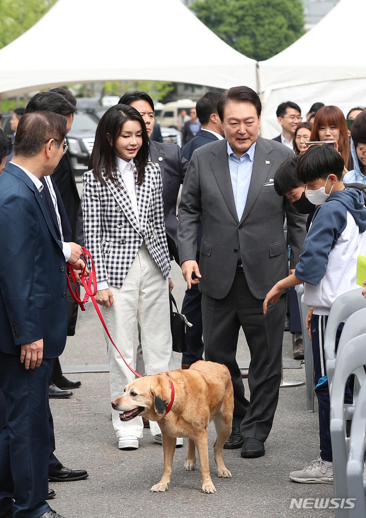 [서울=뉴시스] 홍효식 기자 = 윤석열 대통령과 부인 김건희 여사가 4일 서울 용산 대통령실 앞 미군기지 반환부지에 조성된 용산어린이정원 인근에서 열린 개방행사에 은퇴 안내견 새롬이와 함께 입장하고 있다. 2023.05.04. yesphoto@newsis.com