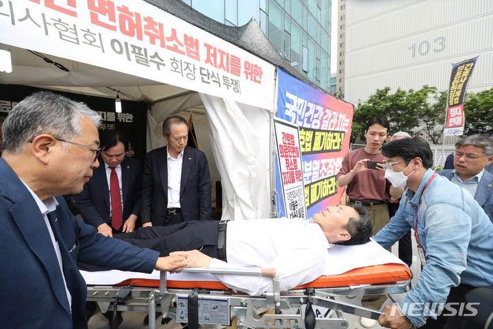 [서울=뉴시스] 김금보 기자 = 이필수 대한의사협회 회장이 4일 오후 서울 용산구 대한의사협회회관 앞 농성장에서 순천향대학교 병원으로 이송되고 있다. 이 회장은 간호법 의료인면허취소법 저지를 위해 8일간 단식 투쟁을 했다. 2023.05.04. kgb@newsis.com