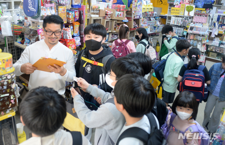 [전주=뉴시스] 김얼 기자 = 제101회 어린이날을 하루 앞둔 4일 전북 전주시 전주북일초등학교 앞 사랑문구에서 임희택 사장이 문구점을 찾은 어린이들과 대화를 나누고 있다. 2023.05.04. pmkeul@nwsis.com