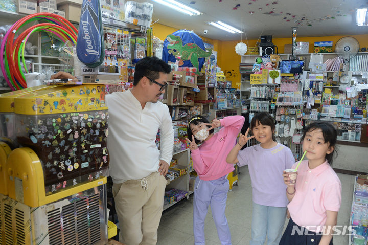 [전주=뉴시스] 김얼 기자 = 제101회 어린이날을 하루 앞둔 4일 전북 전주시 전주북일초등학교 앞 사랑문구에서 임희택 사장이 문구점을 찾은 어린이들과 대화를 나누고 있다. 2023.05.04. pmkeul@nwsis.com