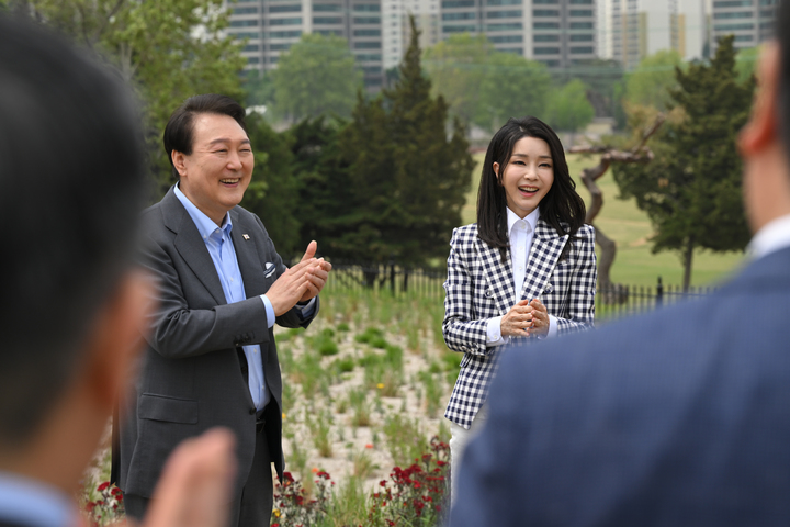 [서울=뉴시스] 윤석열 대통령과 부인 김건희 여사가 4일 서울 용산 대통령실 앞 미군기지 반환부지에 조성된 용산어린이정원 내 전망언덕에서 열린 기념식수 행사에서 박수치고 있다. (사진=대통령실 제공) 2023.05.04. photo@newsis.com *재판매 및 DB 금지