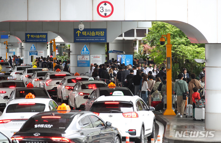[제주=뉴시스] 우장호 기자 = 제주국제공항 1층 택시승차장에 승차 순서를 기다리는 관광객들의 줄이 길게 늘어서 있다. (사진=뉴시스DB) woo1223@newsis.com