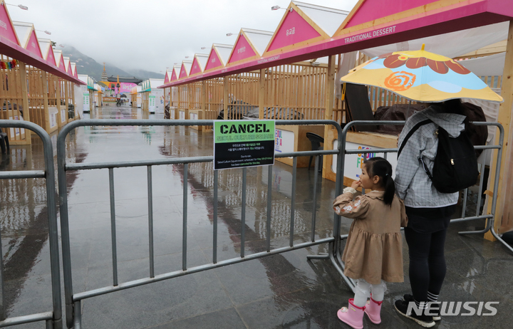 [서울=뉴시스] 김명원 기자 = 어린이날인 5일 오전 서울 종로구 광화문 광장에서 열릴 예정이던 서울컬쳐 스퀘어 행사가 우천으로 취소되어 행사장을 찾은 어린이와 어머니가 발길을 돌리고 있다. 2023.05.05. kmx1105@newsis.com