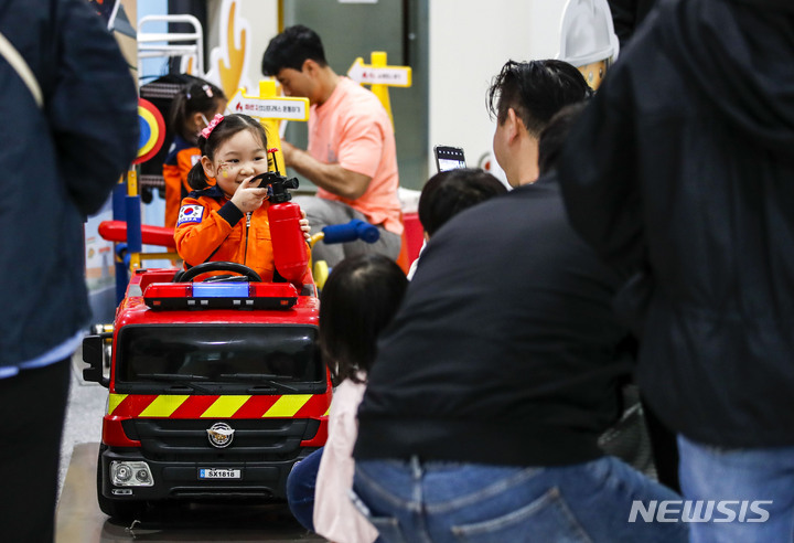 [고양=뉴시스] 정병혁 기자 = 어린이날인 5일 오후 경기 고양시 고양어린이박물관에서 열린 '들썩들썩 놀자 페스티벌: 맘껏 펼침'에서 한 어린이가 소방관 체험을 하고 있따. 2023.05.05. jhope@newsis.com