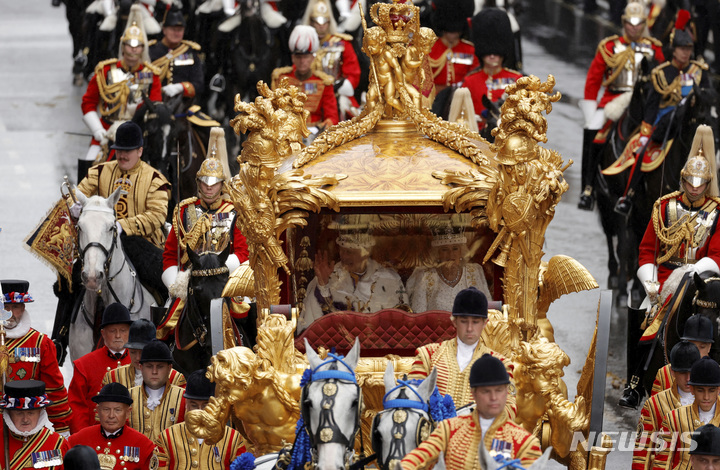[런던=AP/뉴시스]찰스 3세 영국 국왕이 6일(현지시간) 런던 웨스트민스터 사원에서 대관식을 가진 후, 커밀라 왕비와 함께 황금마차에 탑승해 버킹엄궁으로 이동하고 있다. 